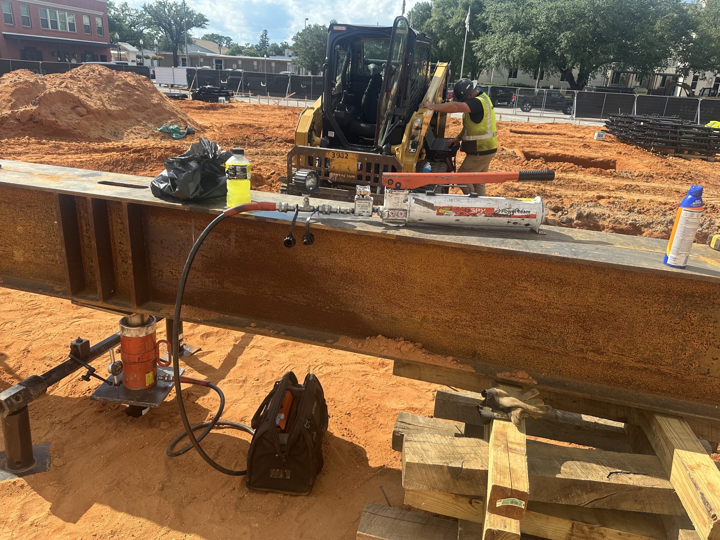 Steel beam and hydraulic ram set up over red clay