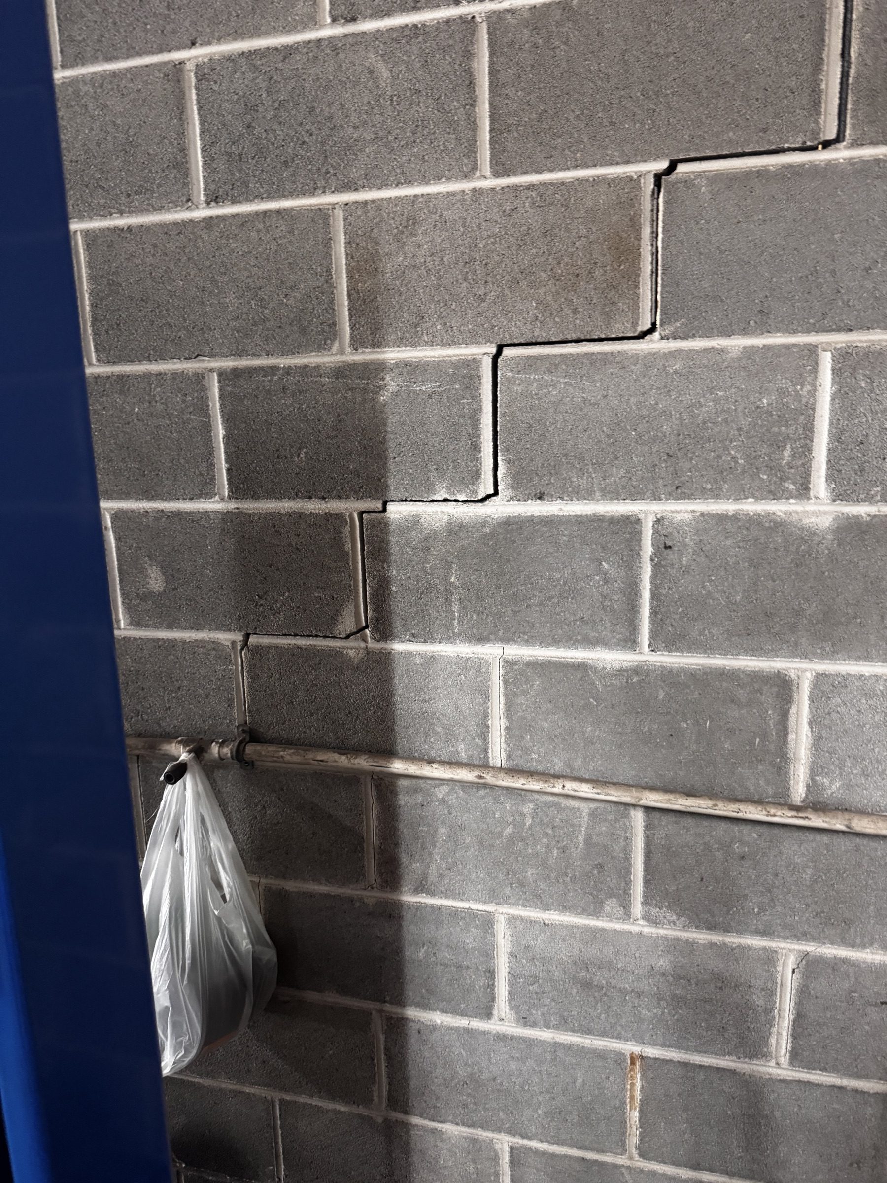 Stair-step crack in a block wall under assessment