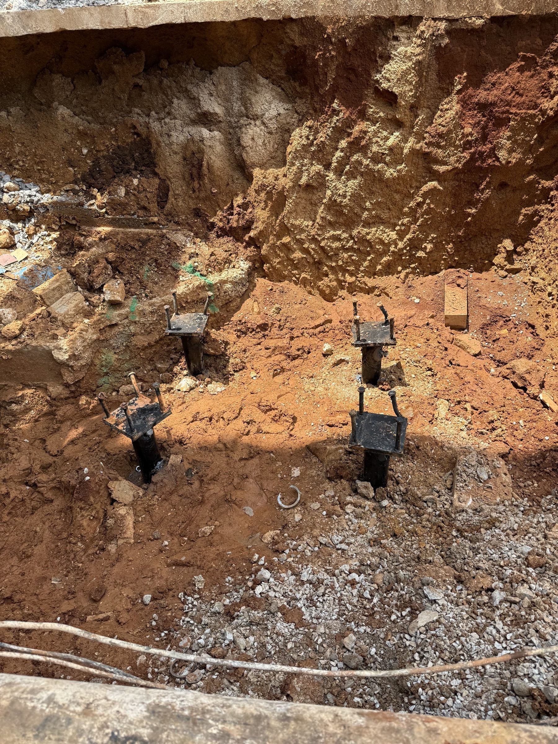 Four completed pile caps and brackets in an open excavation